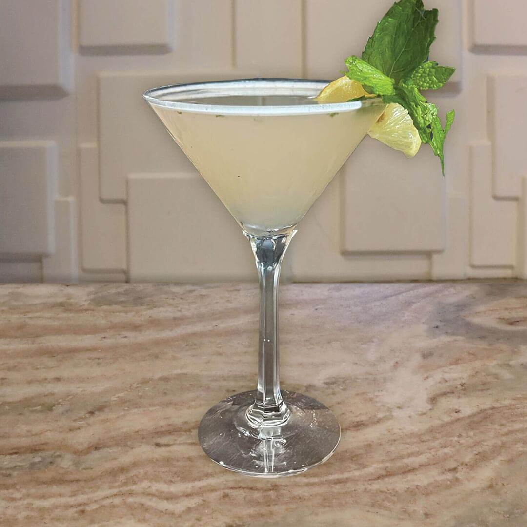 A clear beverage with a hint of purple, garnished with fresh mint leaves.