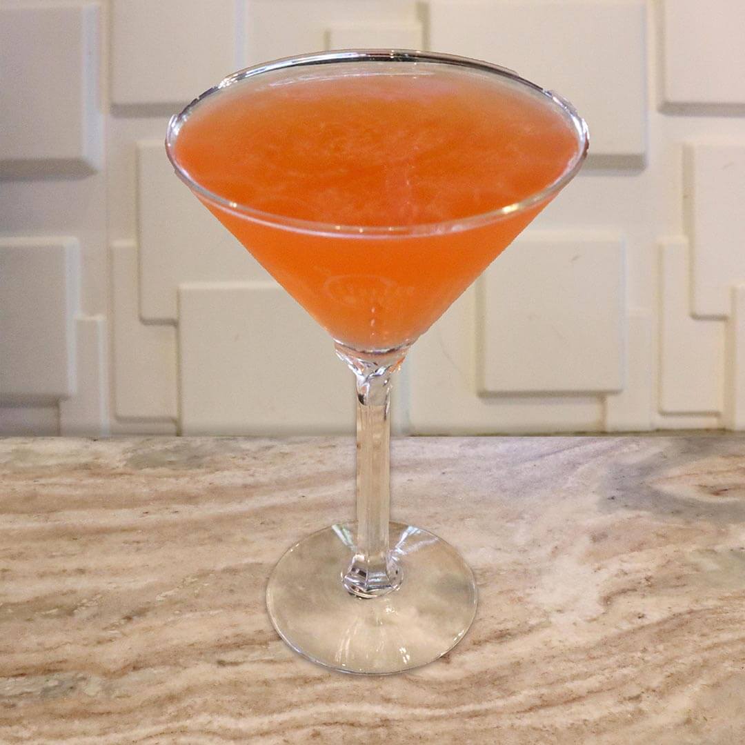 A vibrant orange-red cocktail served in a chilled glass.