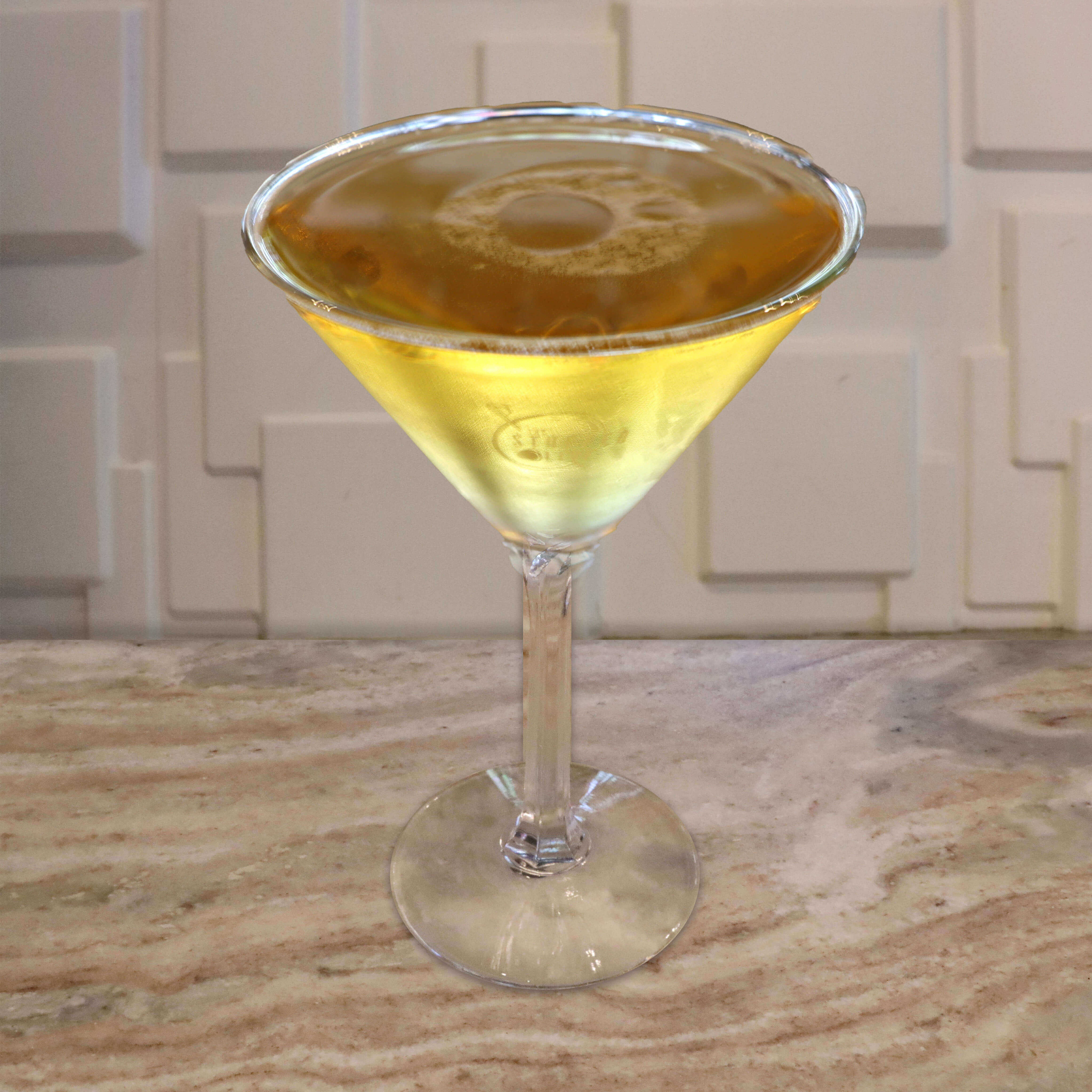 A clear golden-amber cocktail served neat in a chilled glass.