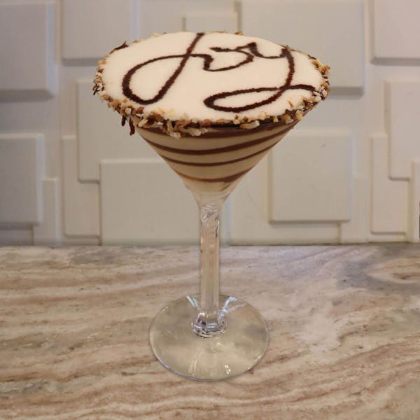 White Chocolate Liqueur, Malibu Rum, Frangelico, Cream, and Chocolate Swirls with A Toasted Coconut Rim