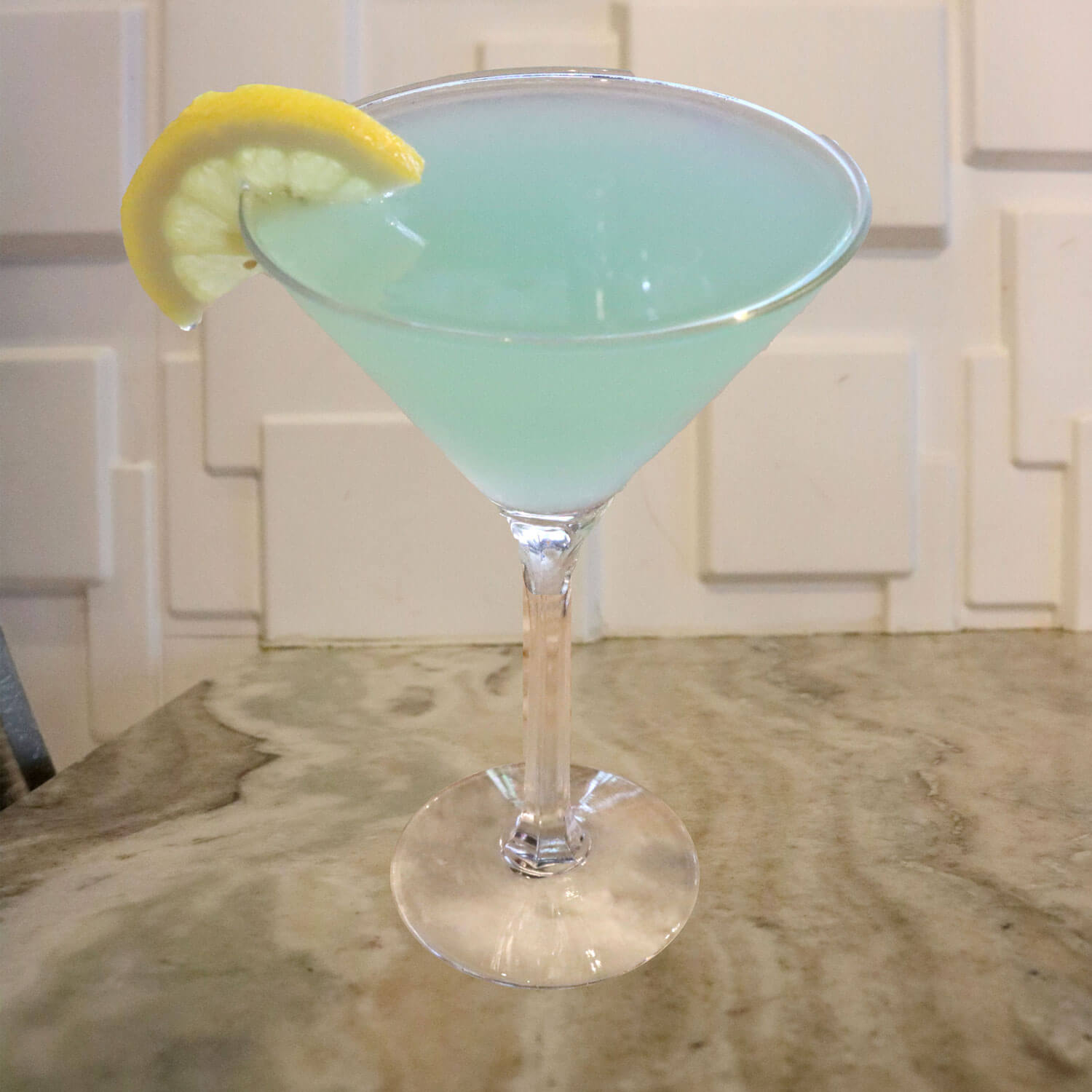 Hpnotiq, Premium Vodka, and a Splash of Lemonade. Garnished With a Lemon Slice