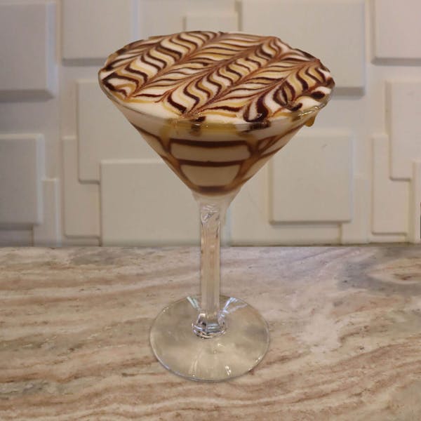Chocolate Vodka, Buttershots, Frangelico, and A Splash of Cream. Garnished with Chocolate and Caramel Swirls in The Glass, and Chocolate and Caramel Feathering