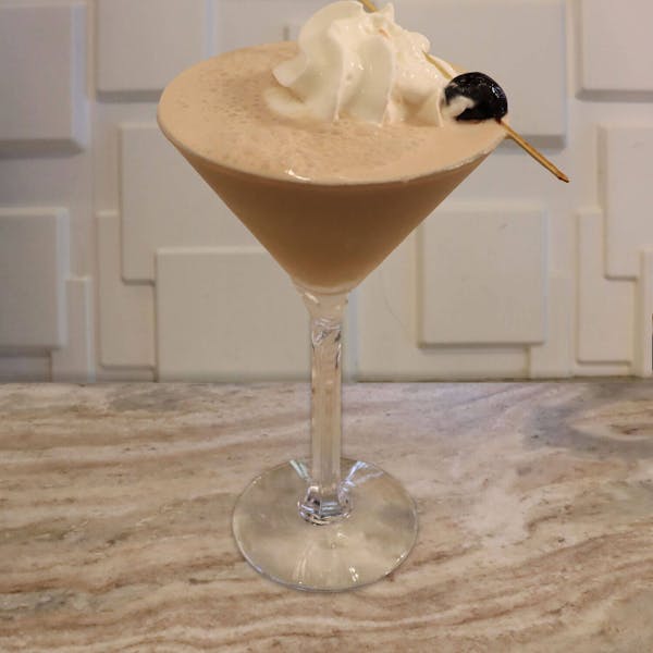 Crème De Banana, Coffee Liqueur, Pineapple Juice, Cherry Juice, Cream. Topped with Whipped Cream and A Luxardo Cherry