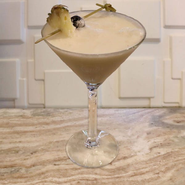 Captain Morgan Pineapple Rum, Malibu Coconut Rum, Coconut Cream, Pineapple Juice, Cream. Garnished With a Pineapple Slice and Luxardo Cherry