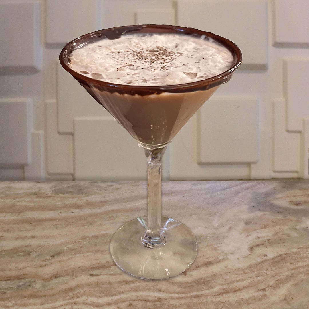 A chocolate espresso cocktail in a glass with a chocolate-coated rim, topped with a creamy froth and a light dusting of cocoa powder.
