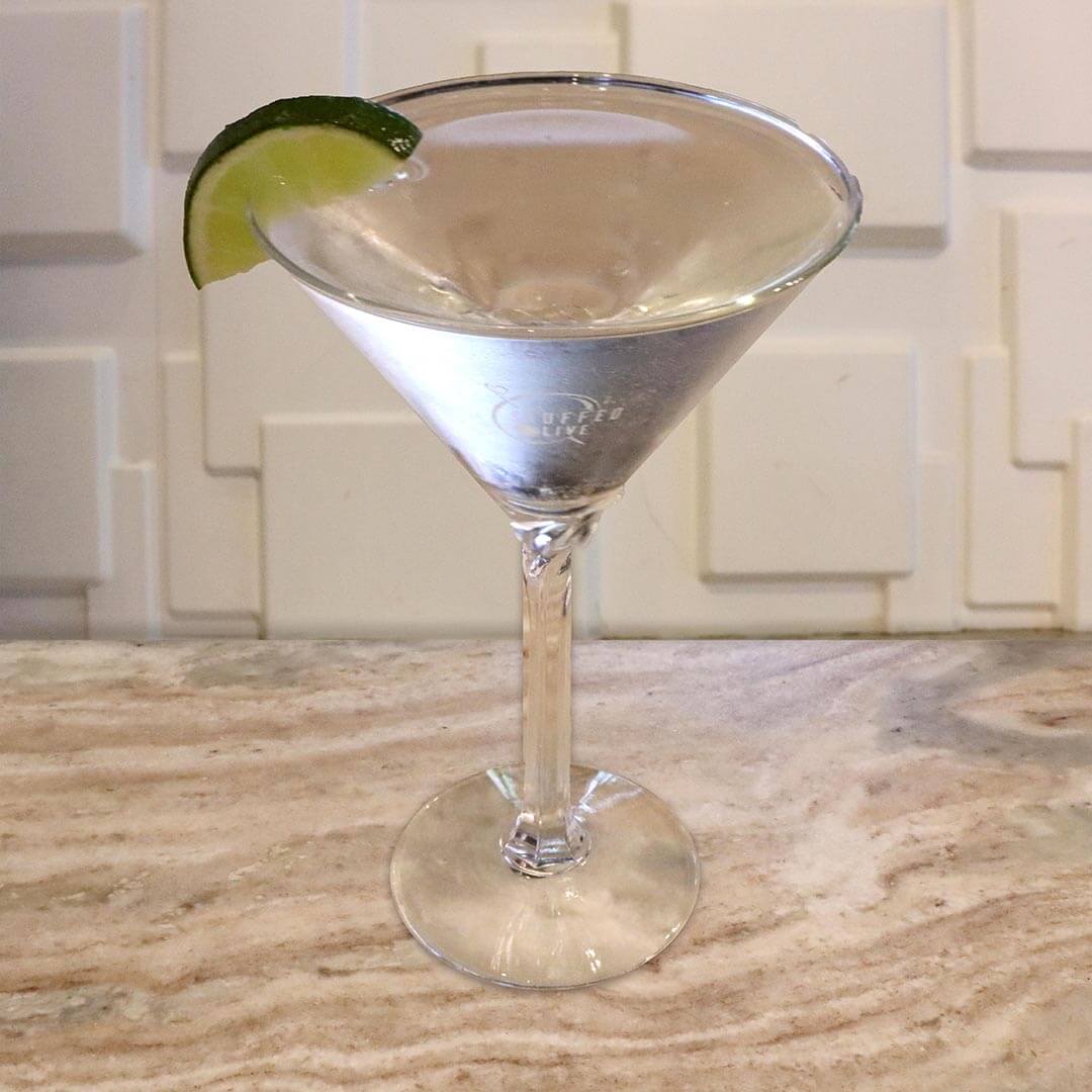 A crisp and clear cocktail garnished with a fresh green lime wheel.
