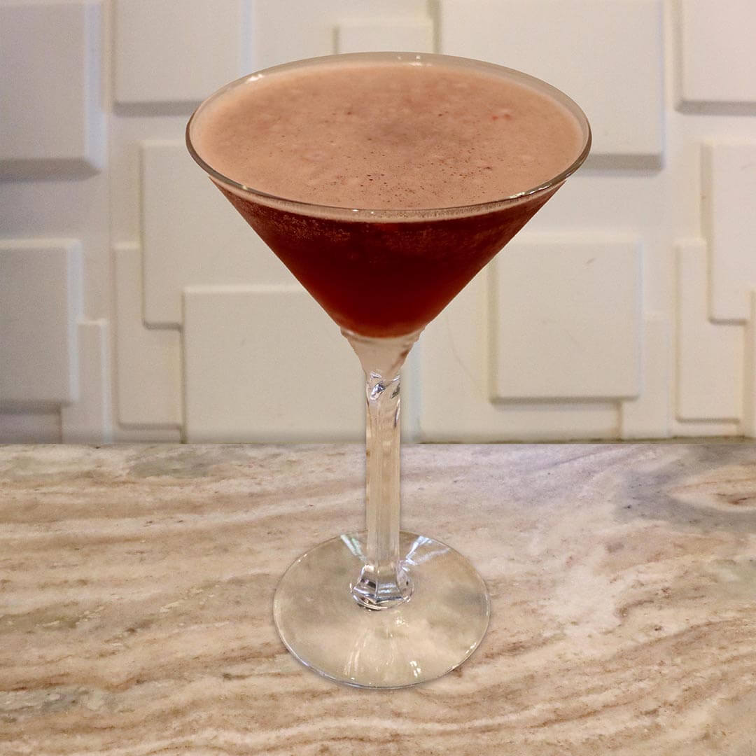 A deep red-pink colored cocktail in a chilled glass.