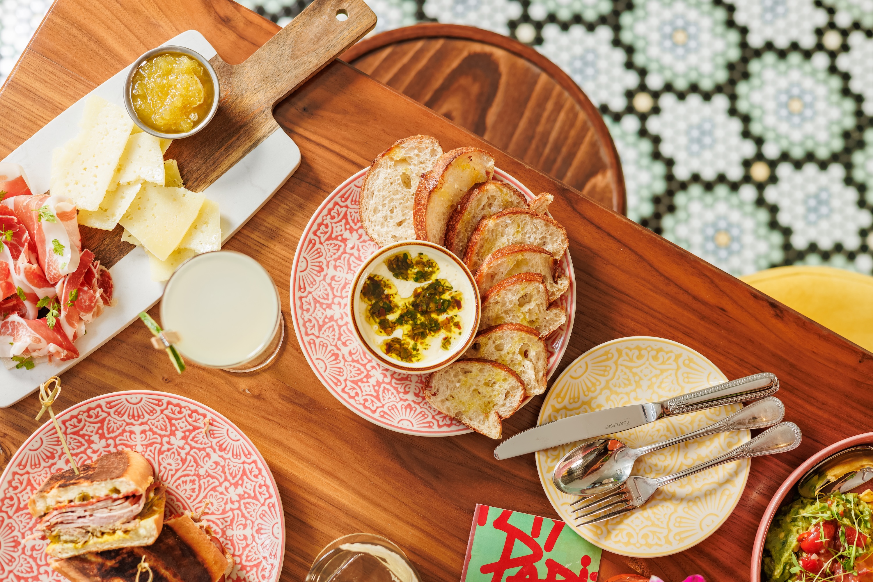 a table with plates of food and glasses of liquid