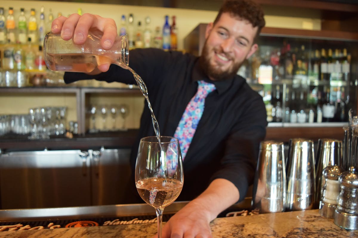 a person sitting at a table with wine glasses