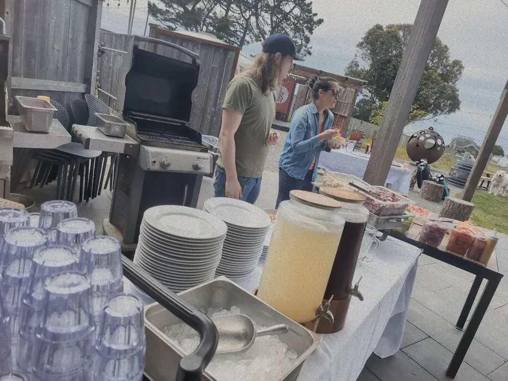 a group of people standing next to a table with plates and glasses