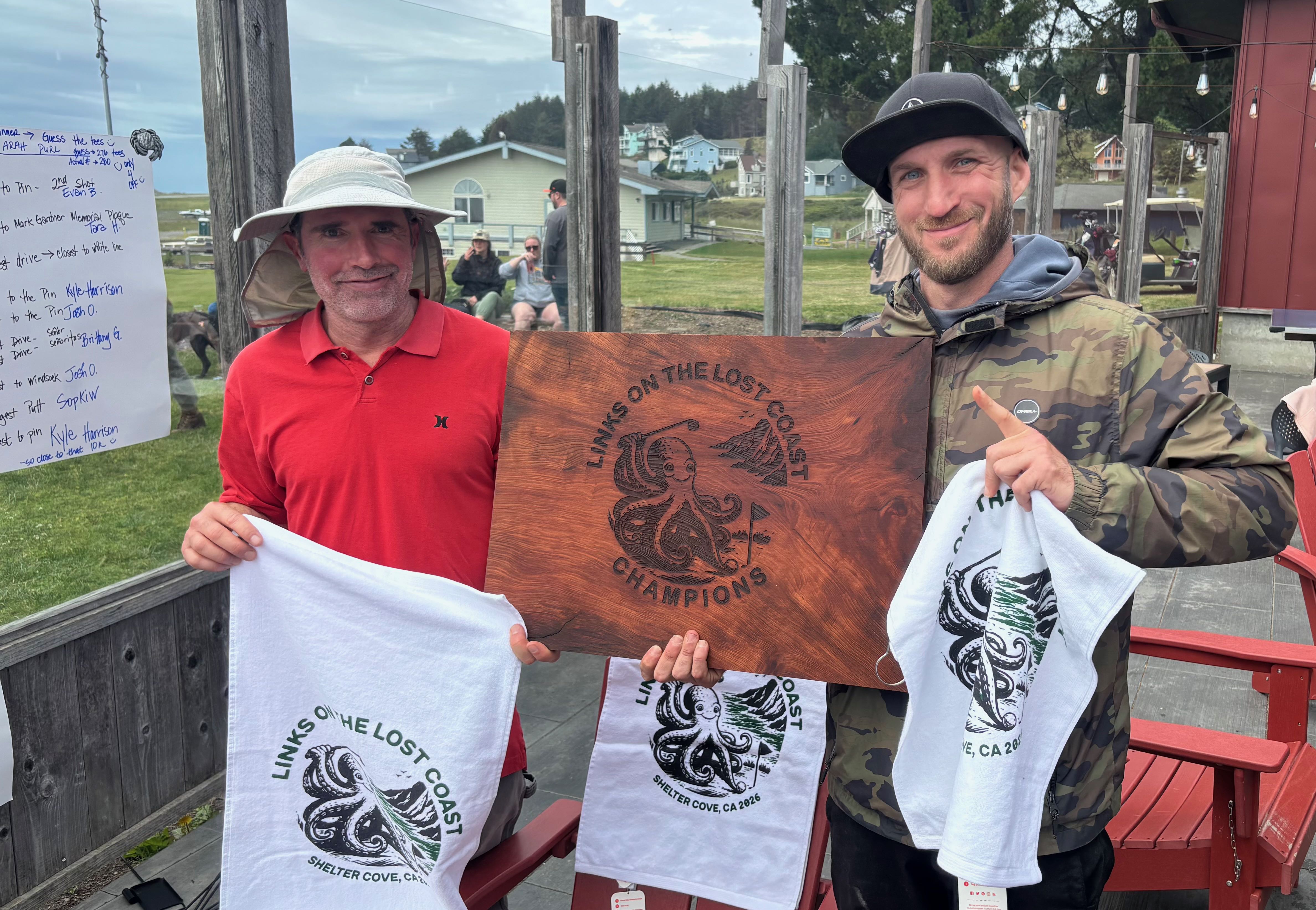 two men holding up a wooden sign