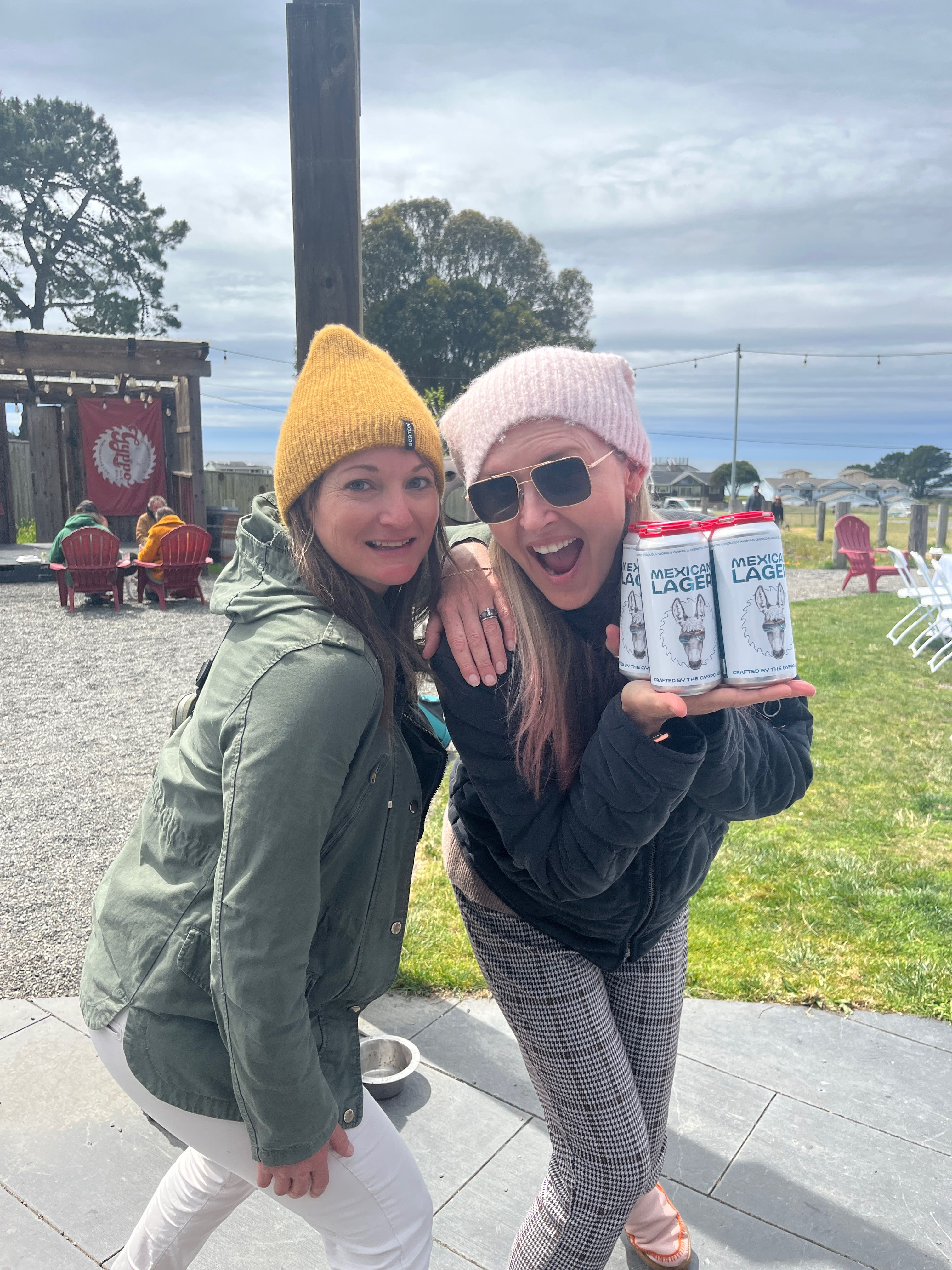two women holding cans of beer