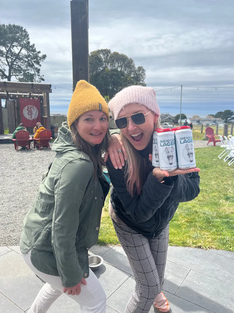 two women holding cans of beer