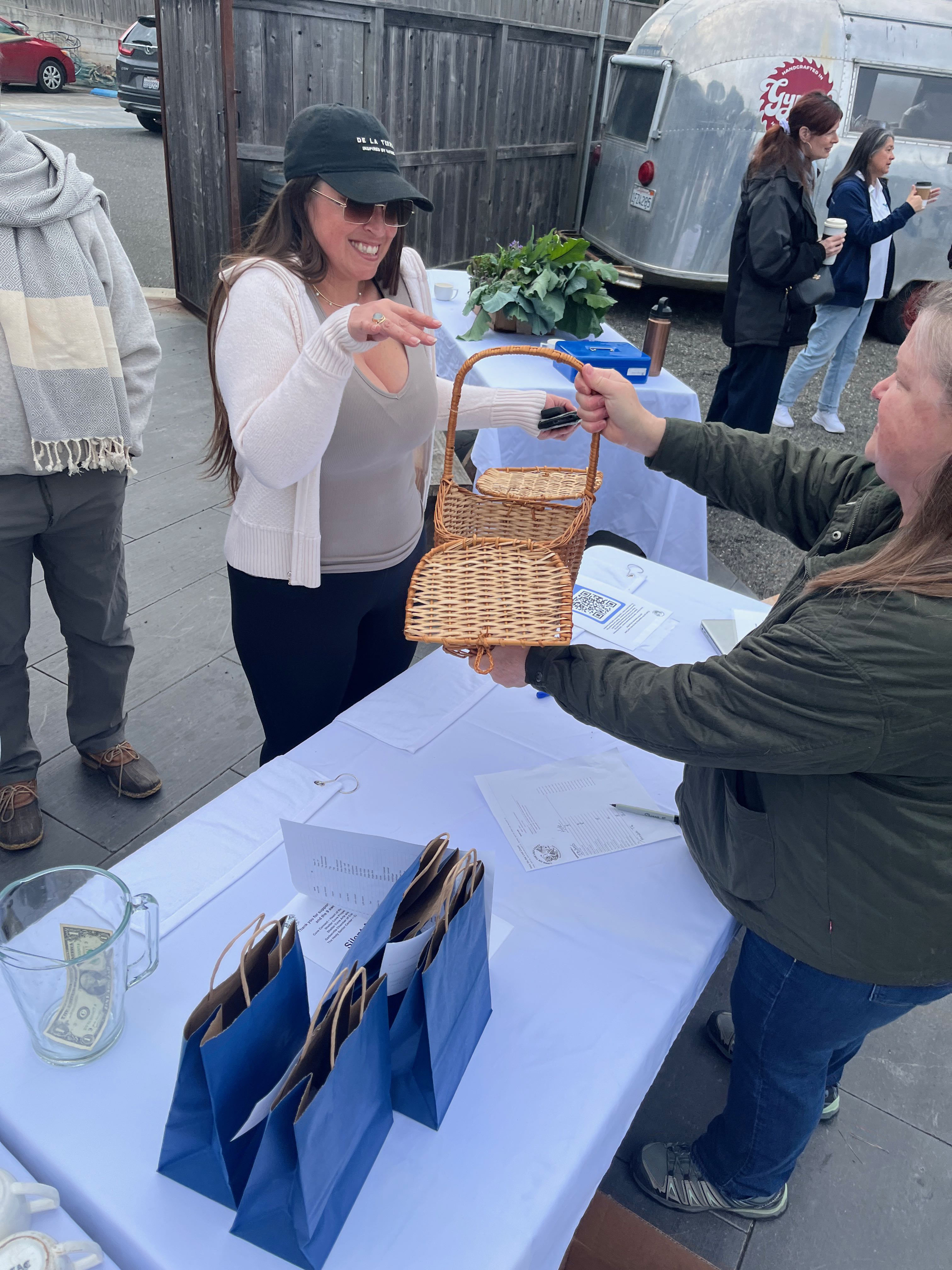 a woman handing a basket to a woman