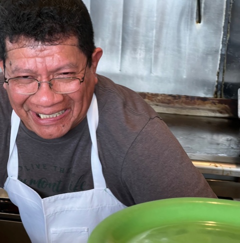 a man sitting at a table smiling for the camera