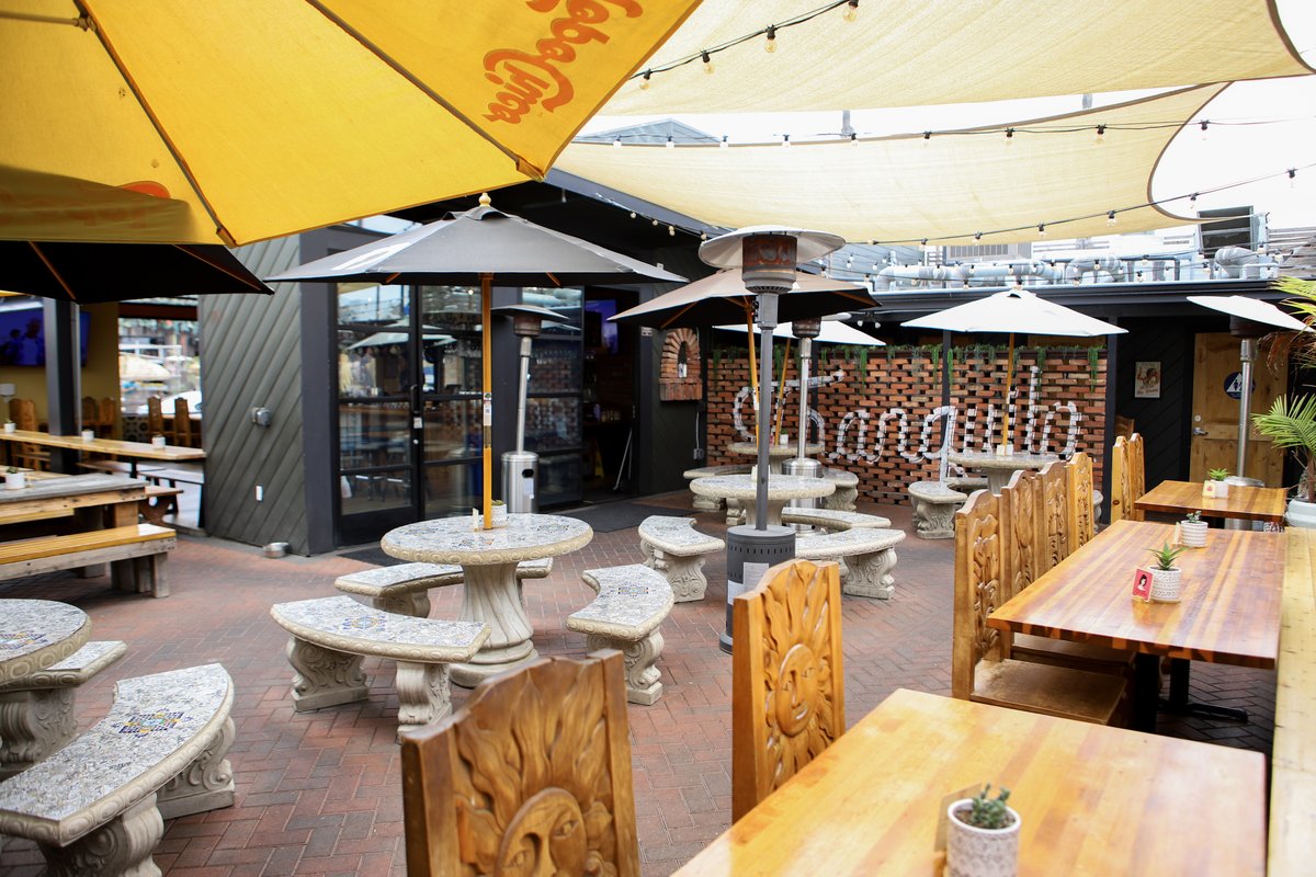 A warm restaurant ambiance with wooden tables and chairs set for patrons