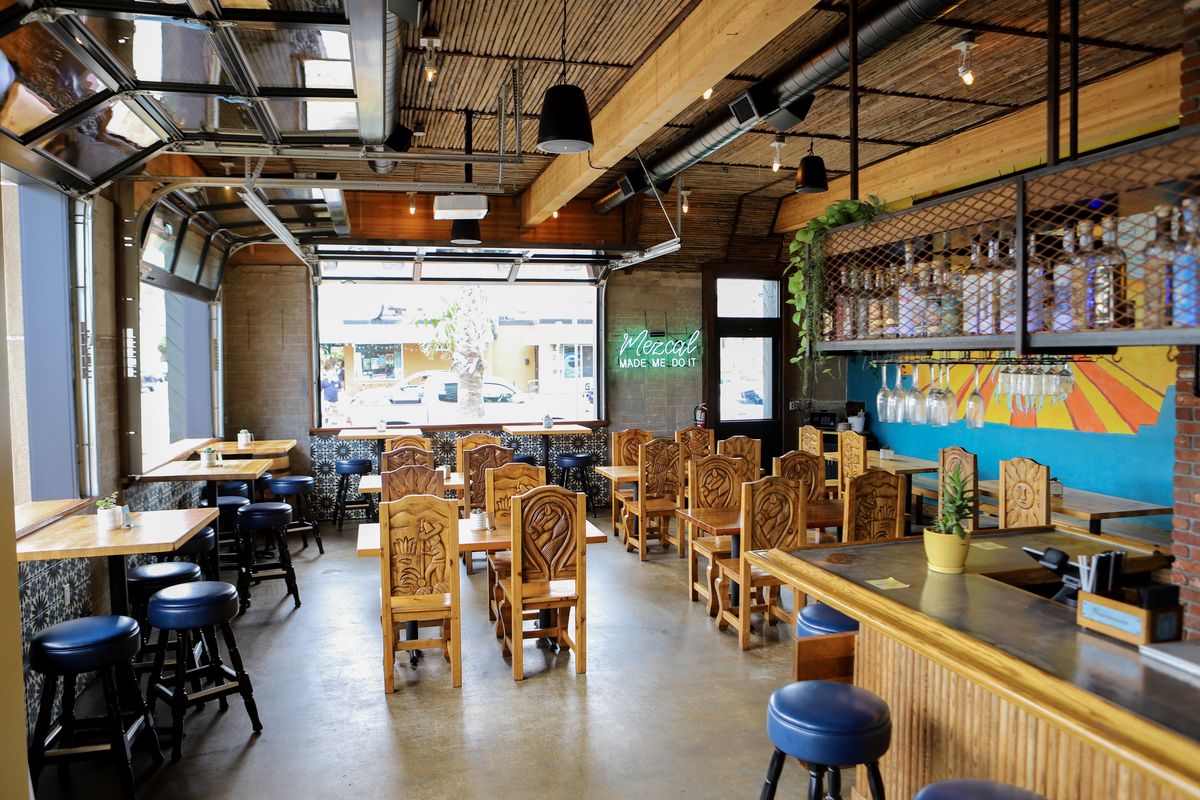 A cozy restaurant featuring wooden tables and chairs arranged for dining