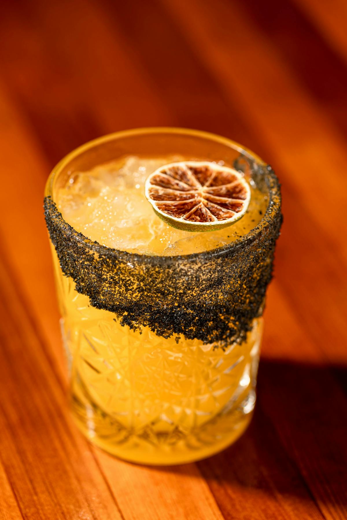 a glass of orange juice on a wooden table
