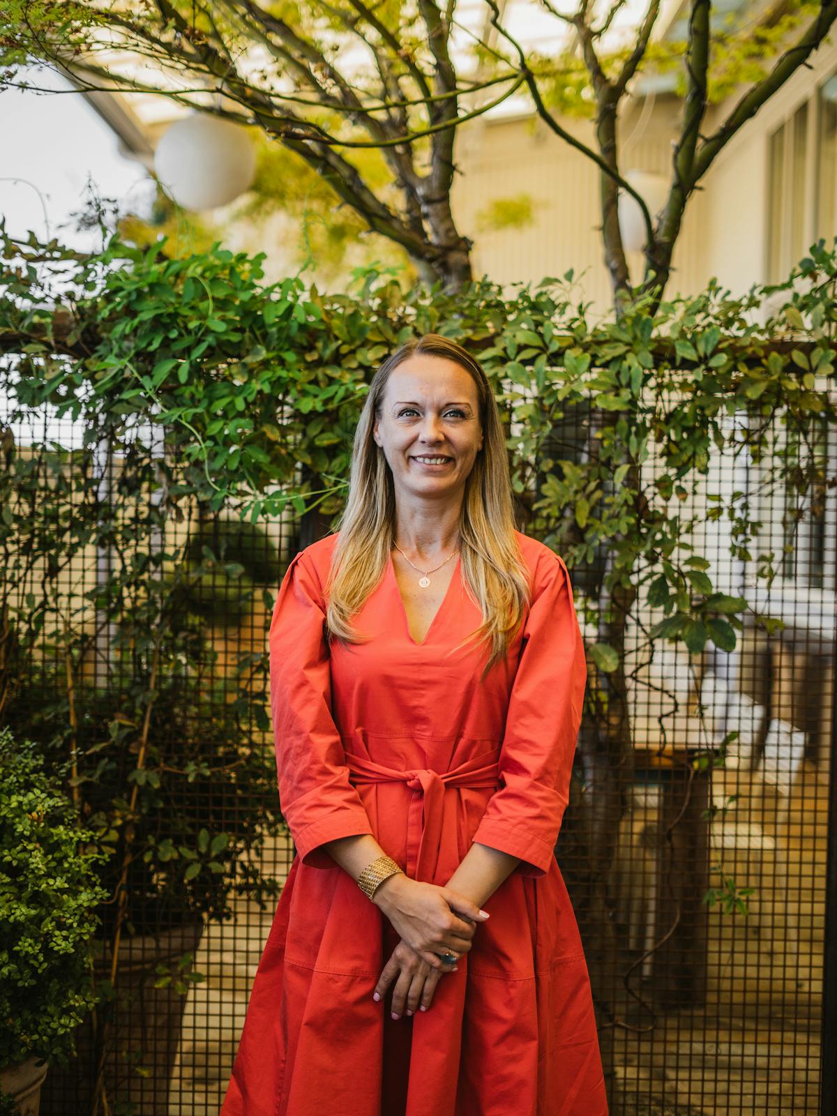 a woman standing in front of a fence