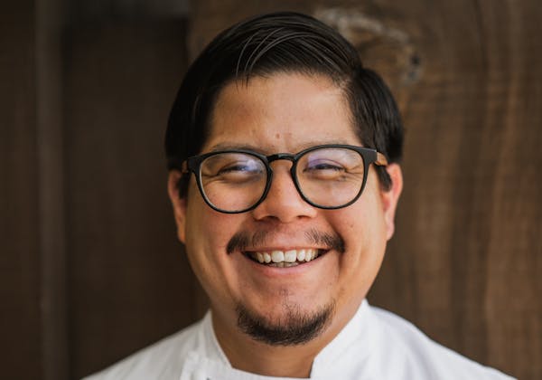 a man wearing glasses and smiling at the camera