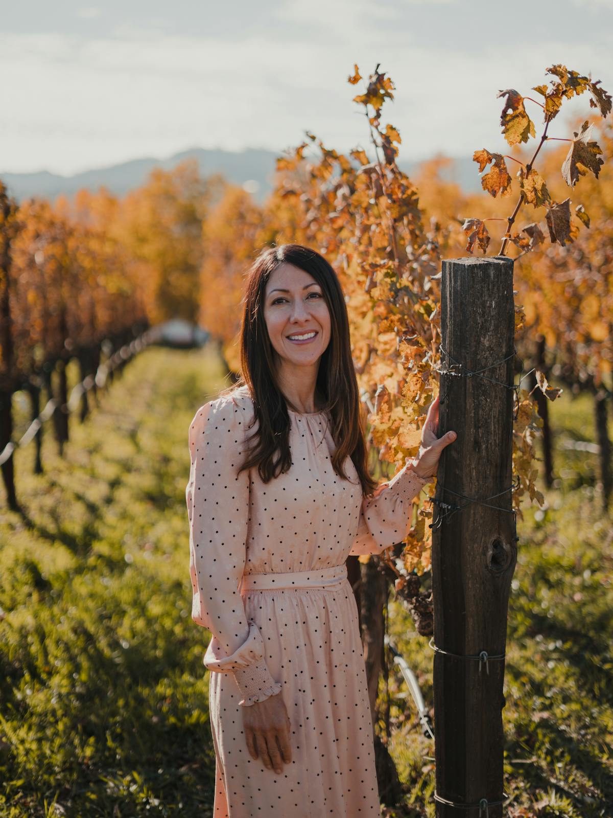 a woman standing in front of a tree posing for the camera