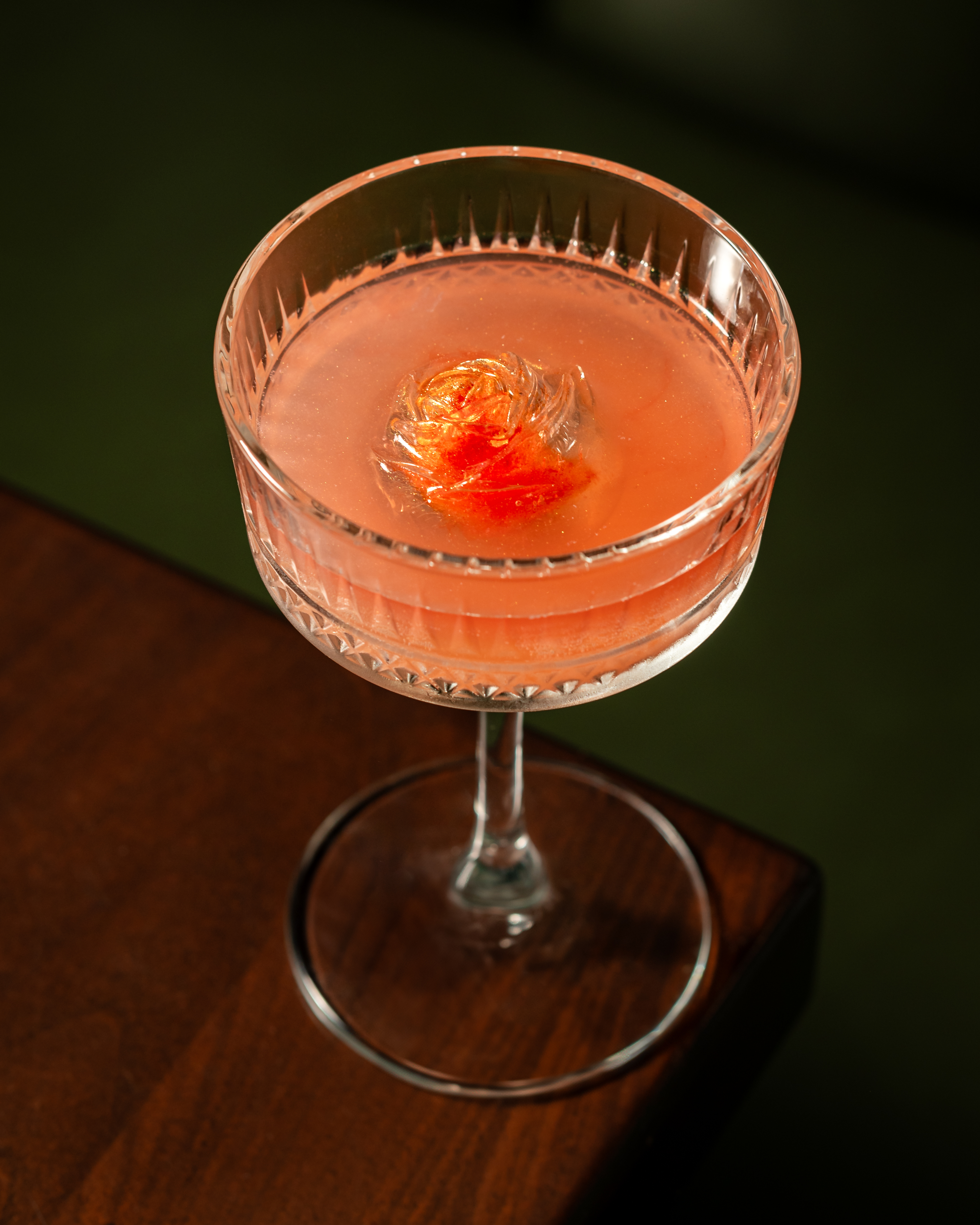 a glass of wine sitting on top of a wooden table