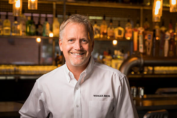 a man standing in front of a restaurant