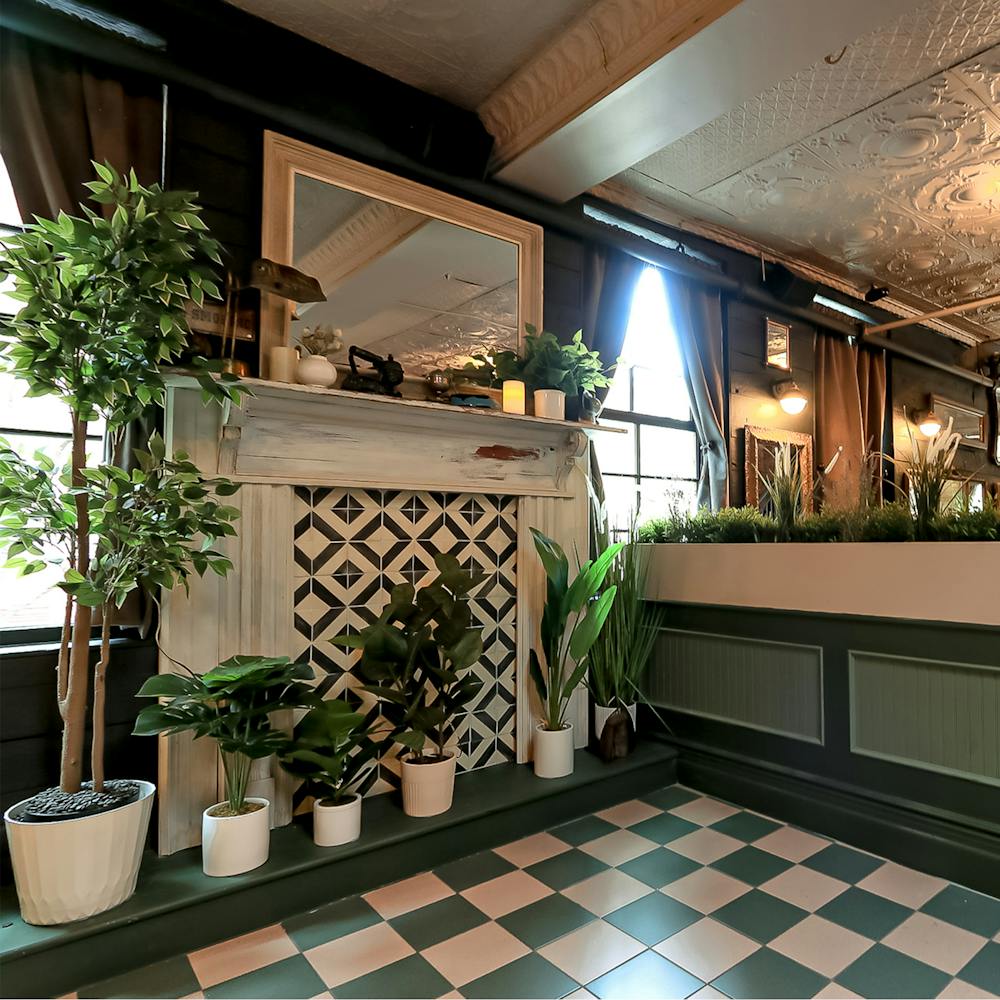 a green tiled floor and a faux fireplace