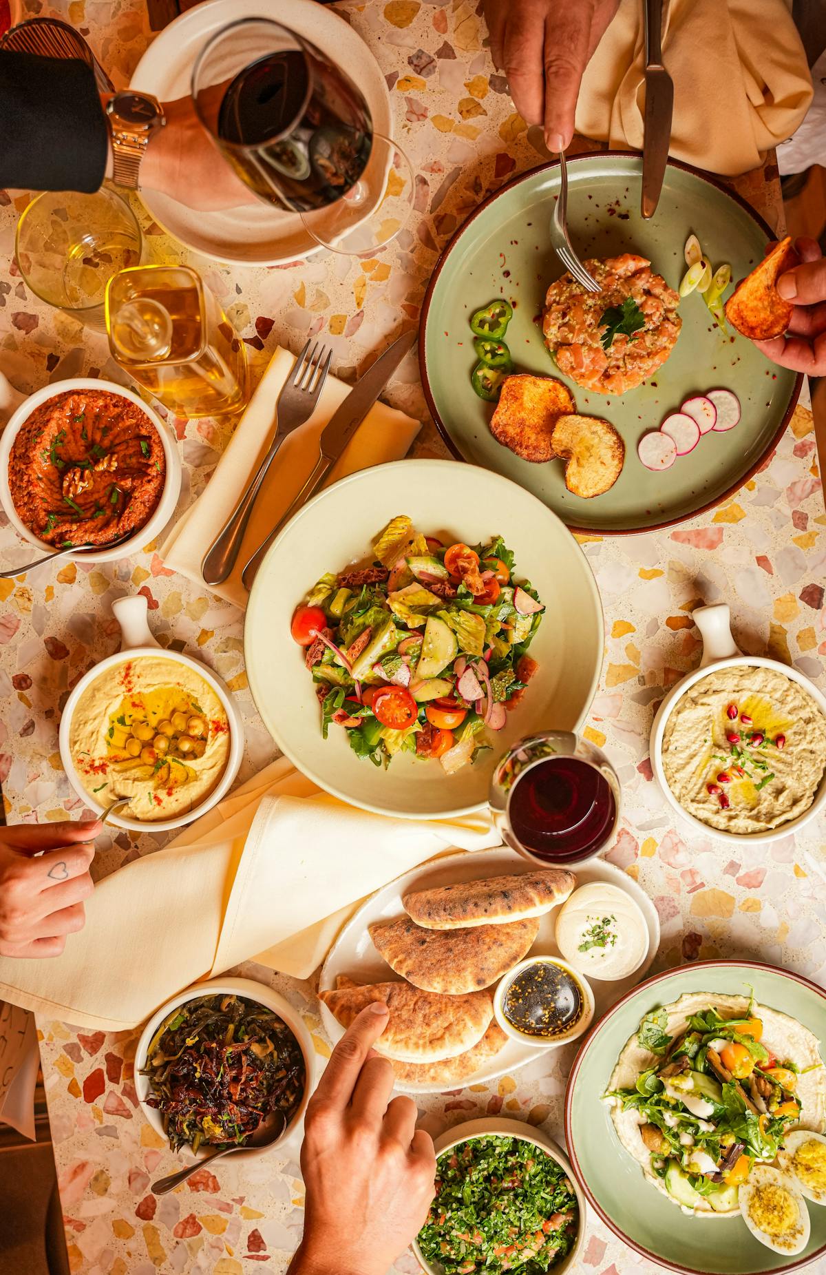 a table at BIS with a variety of Kosher Middle Eastern dishes including fattoush salad and mezze such as hummus, baba ghanoush, and muhammara