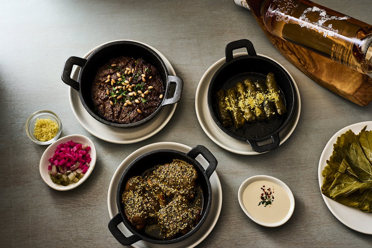 a table at BIS with a variety of Kosher Middle Easter dishes including kibbeh, yabra, zaatar chicken, and tahini