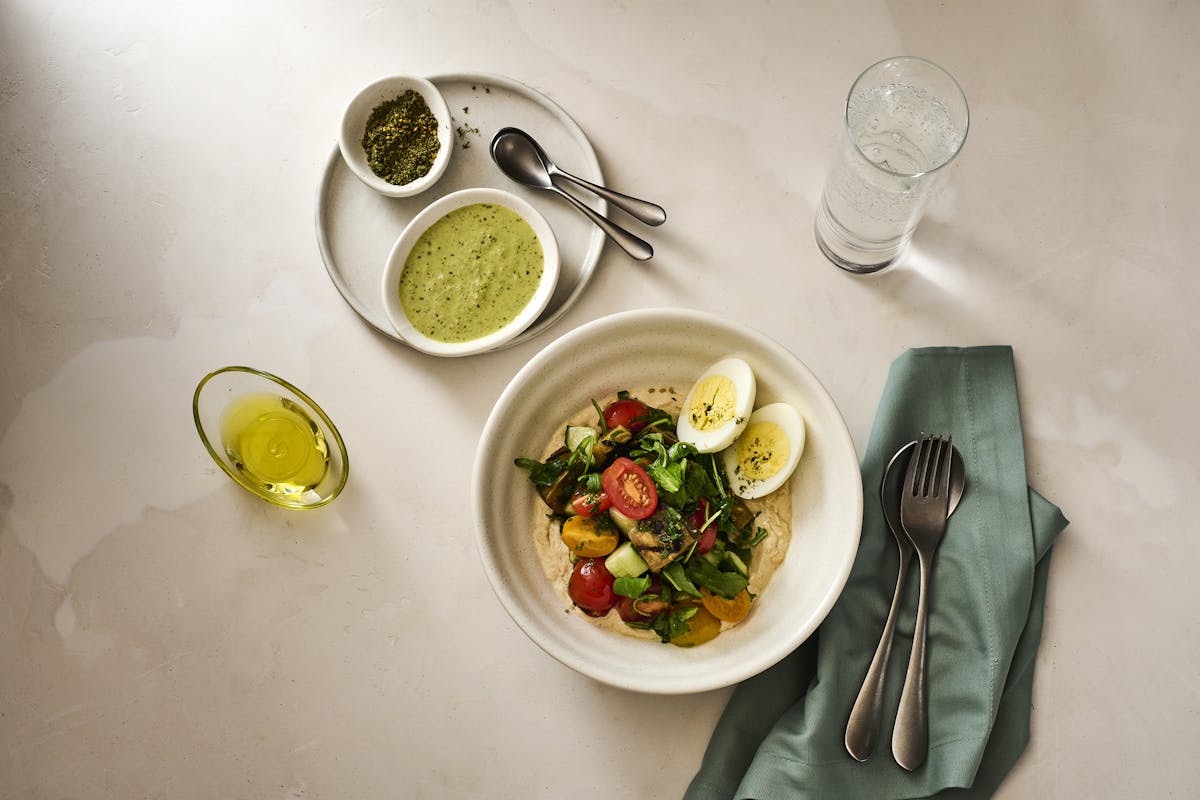 a plate with sabich salad on a table at BIS