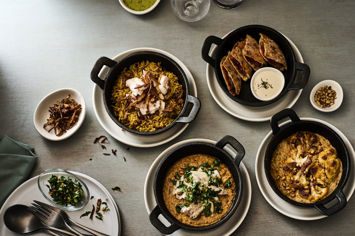 four traditional middle eastern dishes sitting on a table