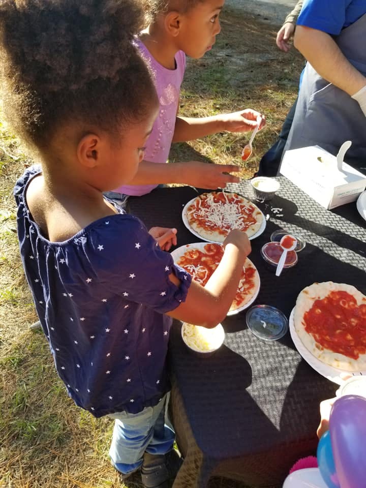 a group of people around a table eating pizza