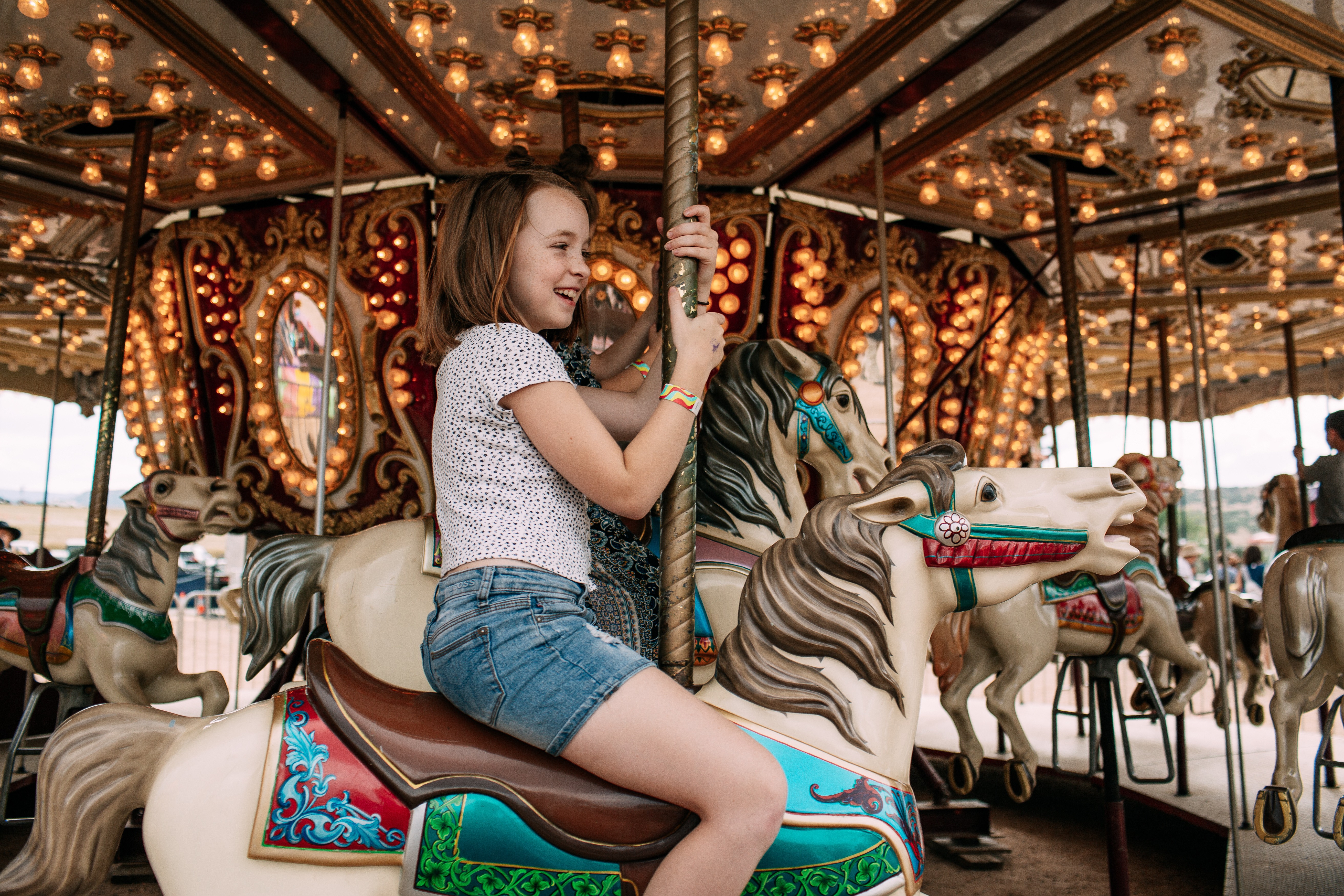 a woman sitting in front of a carousel