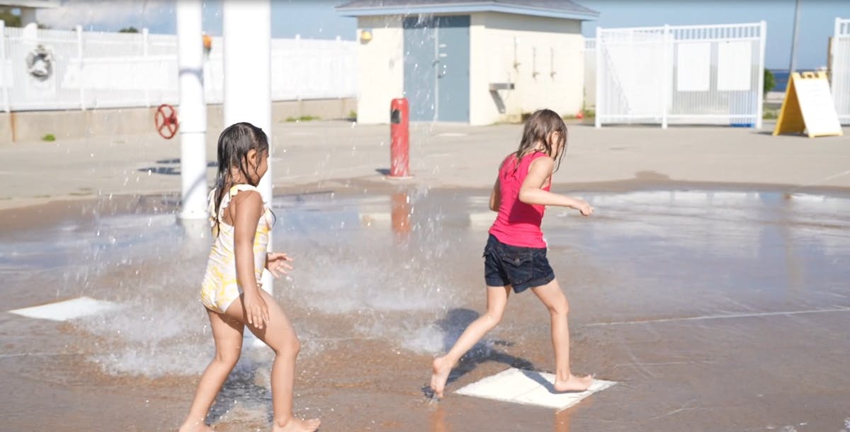 a little girl standing in front of a building