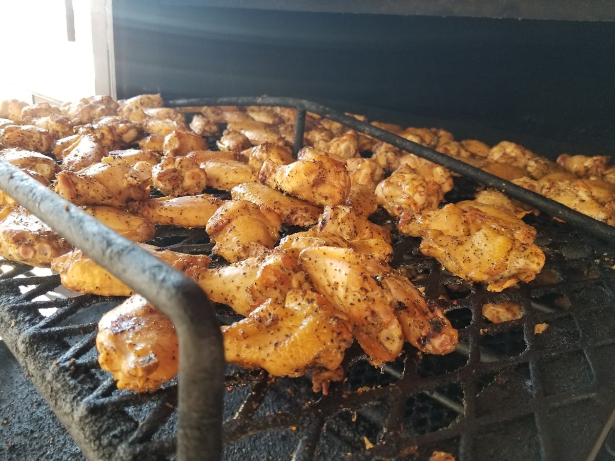 a grilled filled with lots of chickens wings