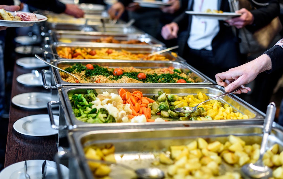 a group of people sitting at a table with a plate of food