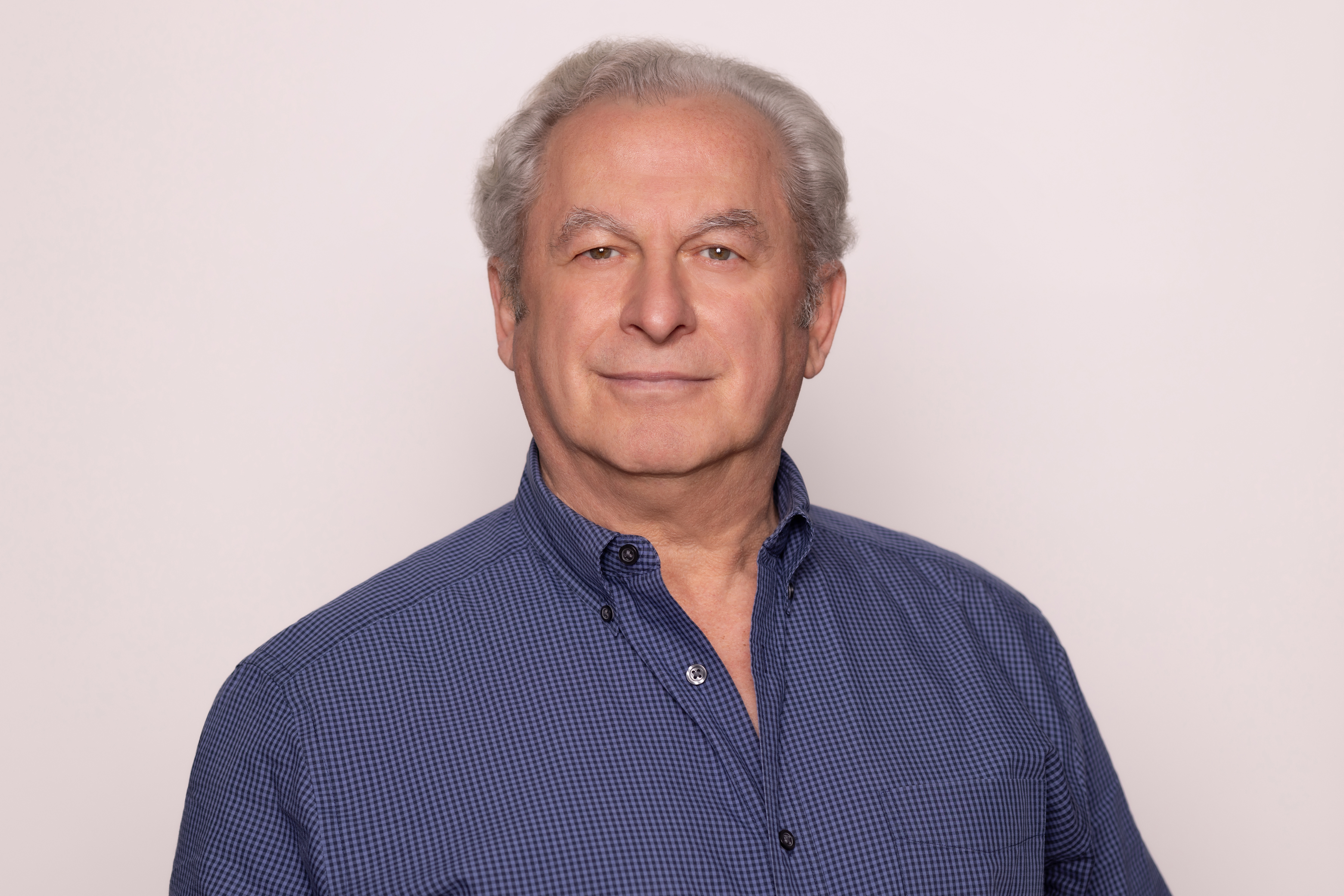 A older gentleman wearing a navy blue button-up dress shirt
