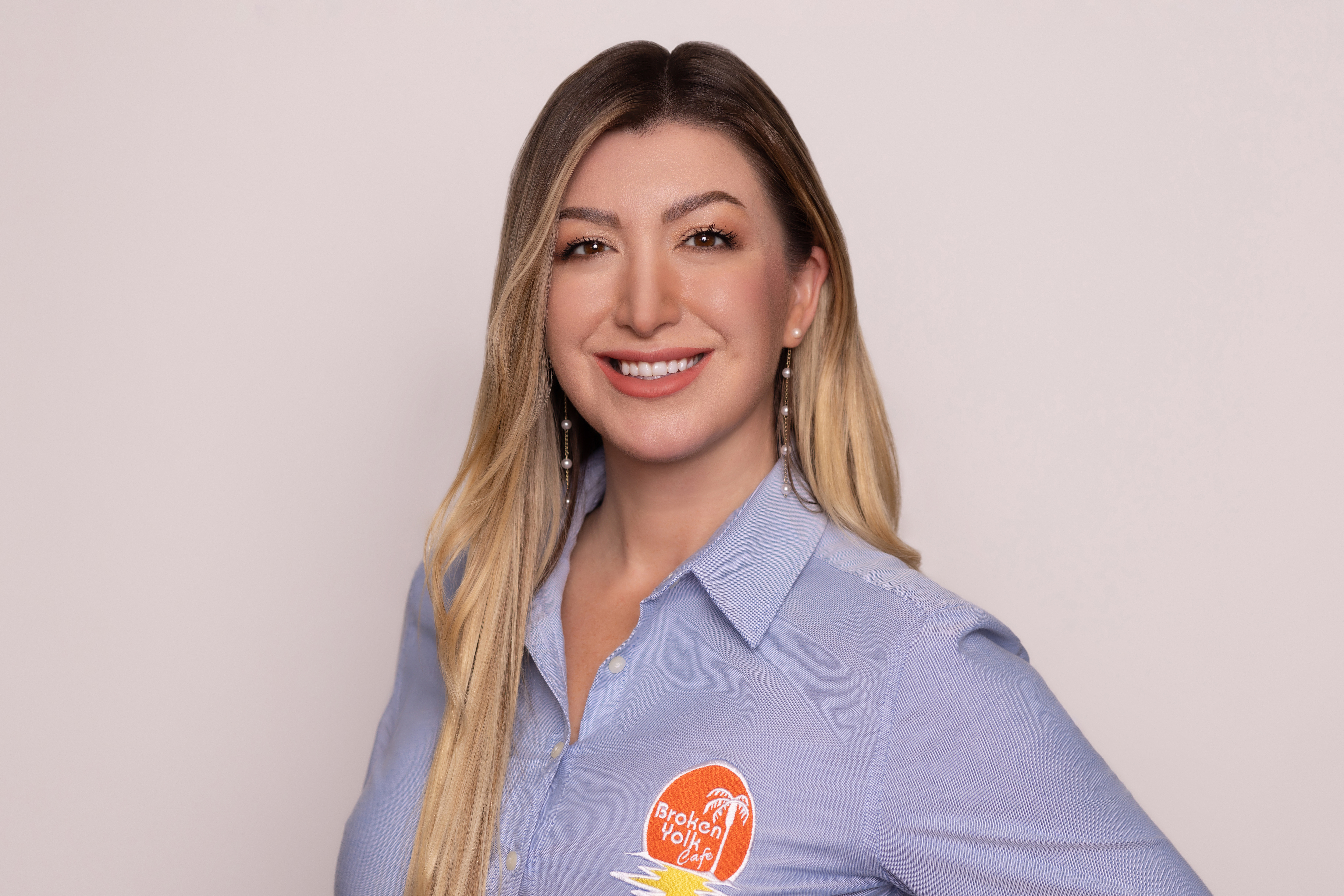 A woman wearing a blue shirt and smiling at the camera.