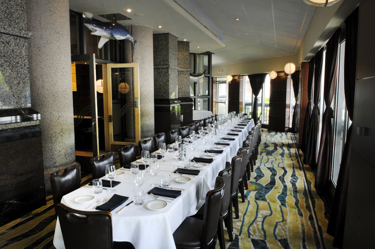 a room with a large table set with plates and wine glasses