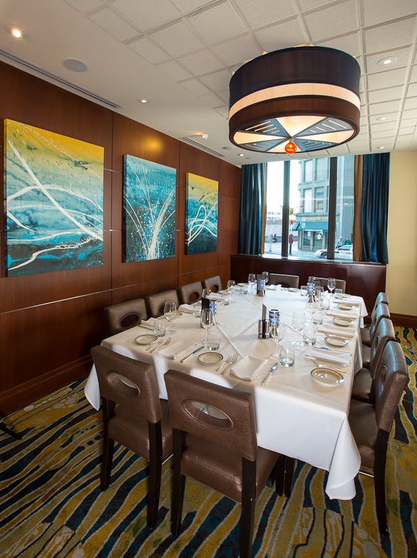 a room with a large table set with plates and wine glasses