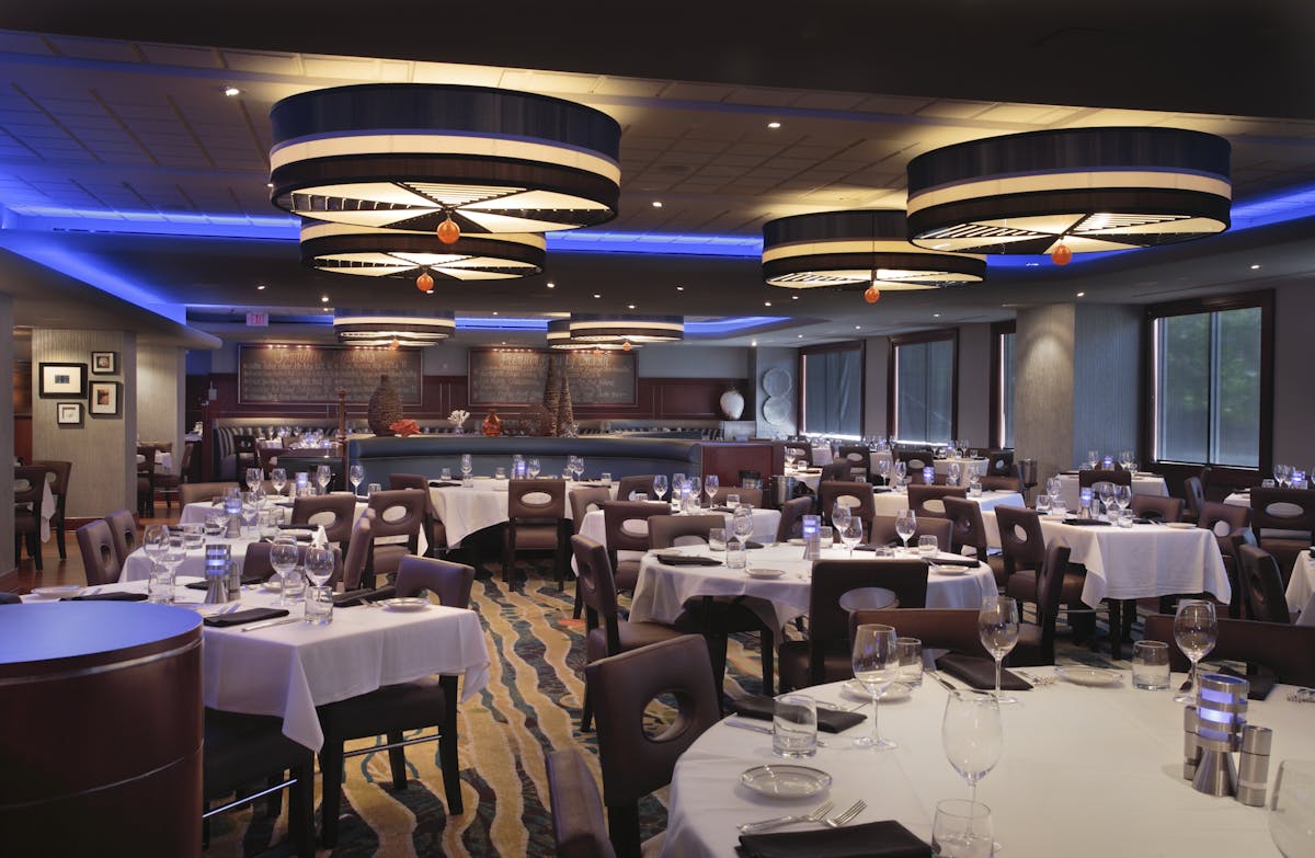 a room filled with dining tables, furniture and a large window