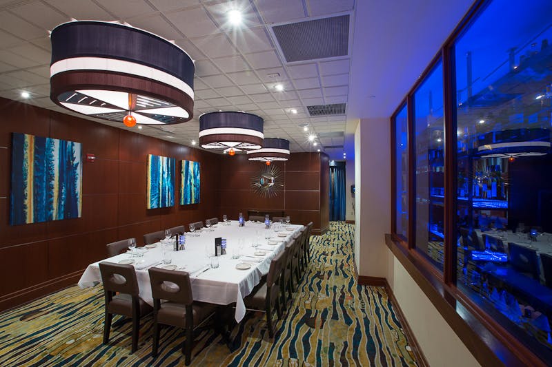 a room with a large table set with plates and wine glasses