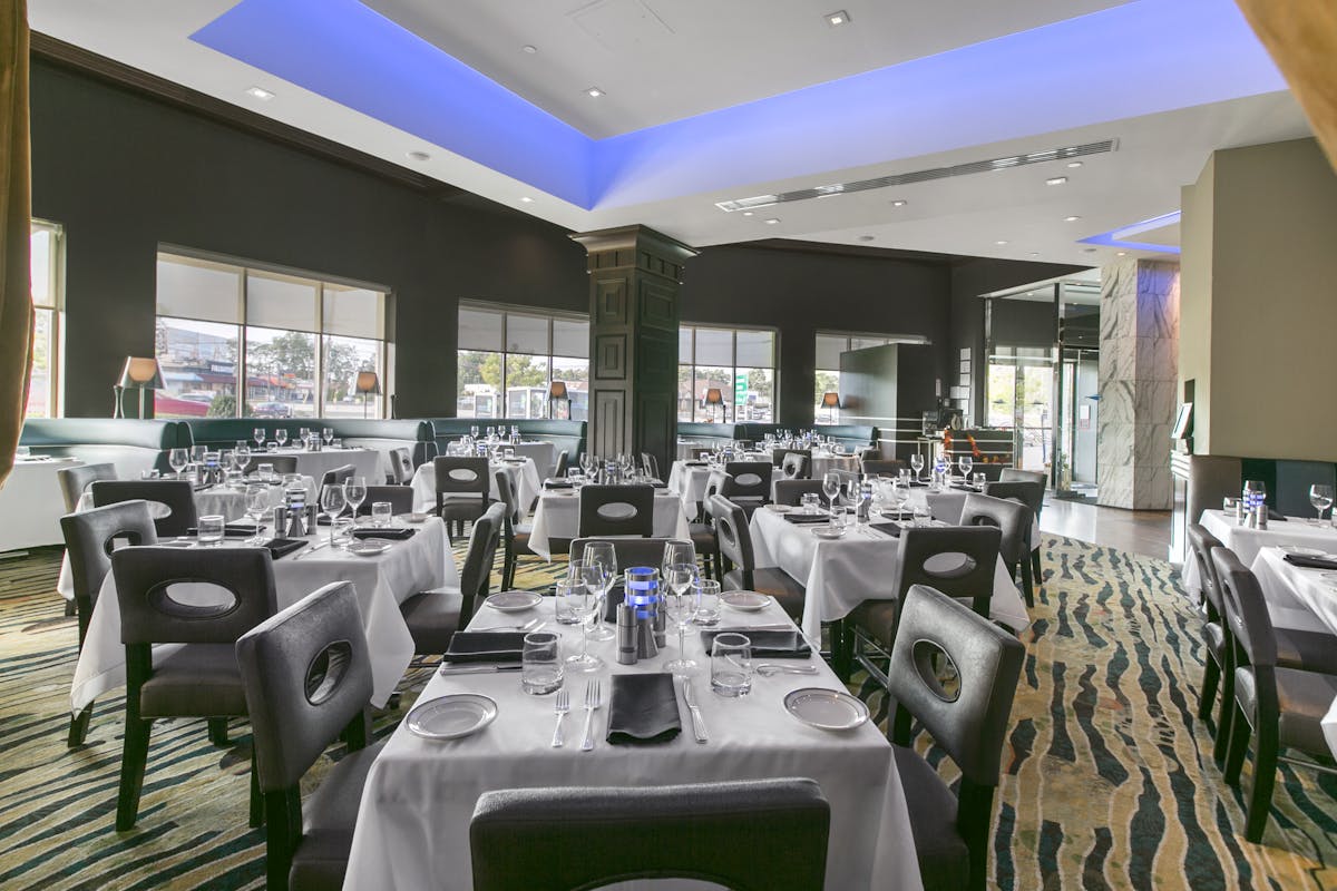 a room filled with dining tables, furniture and a large window