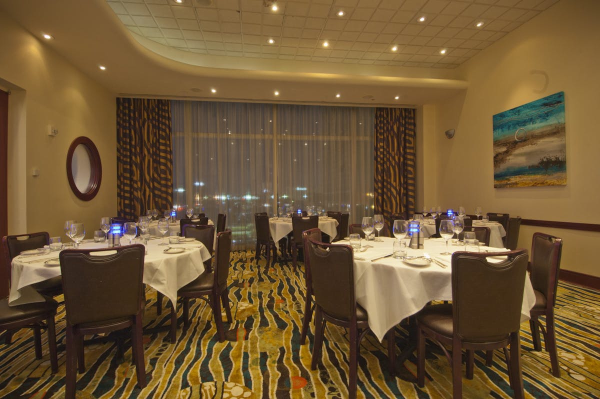 a room filled with dining tables, furniture and a large window