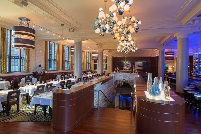 a room filled with dining tables, furniture and a large window
