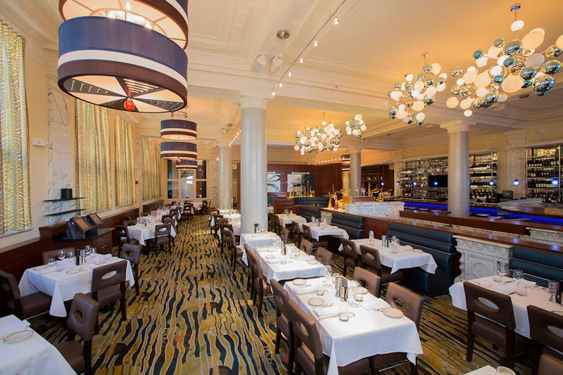 a room filled with dining tables, furniture and a large window