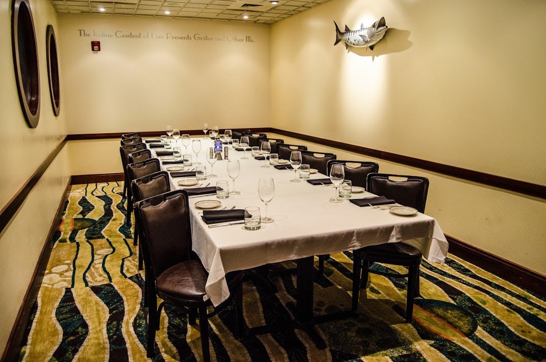 a room with a large table set with plates and wine glasses