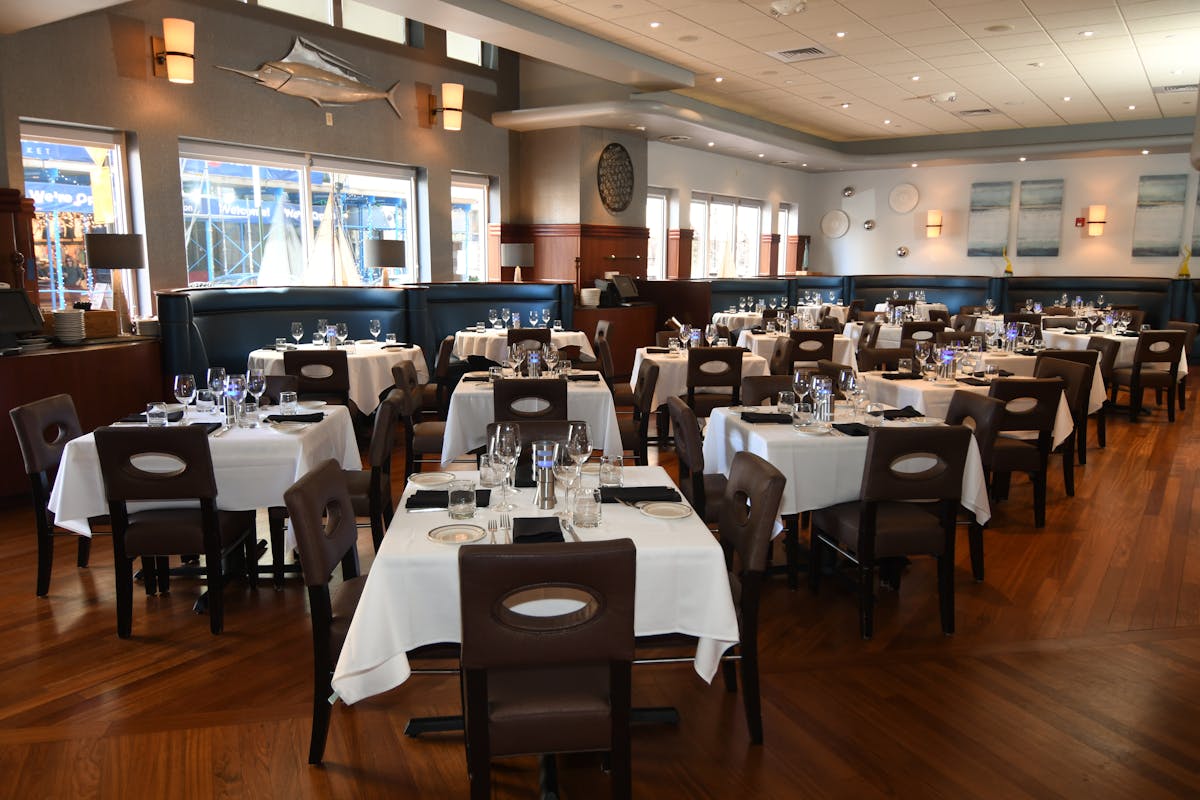 a room filled with dining tables, furniture and a large window