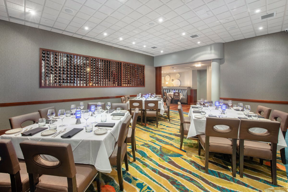 a room filled with dining tables, furniture and a large window